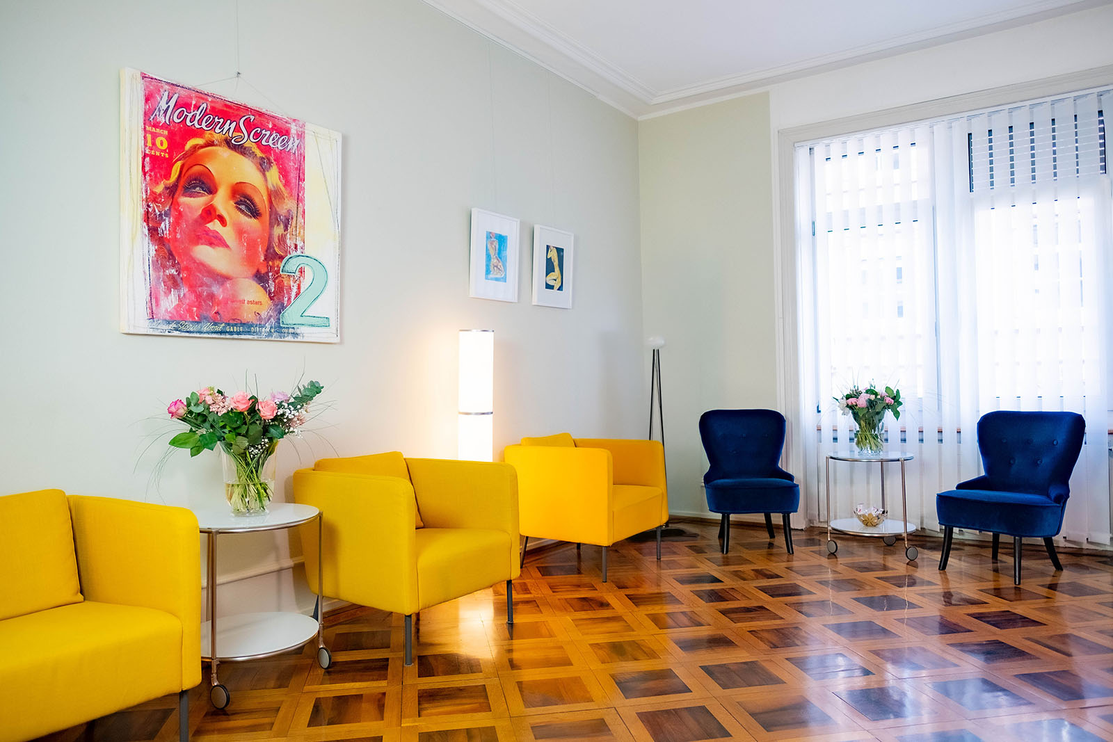 Waiting room of the practice with yellow and blue armchairs.